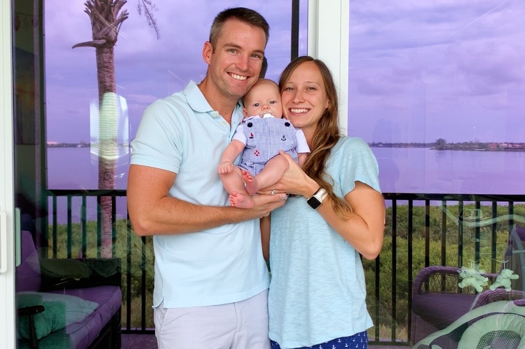 Jordan, Vanessa, and their first baby at a lakeside home