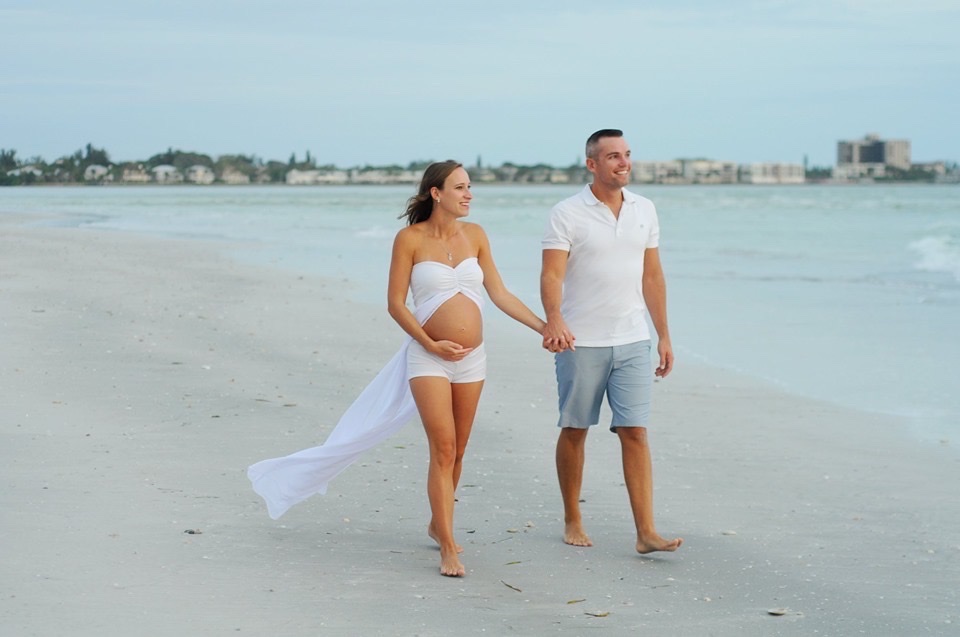 Jordan and Vanessa walking the beach while expecting their first child